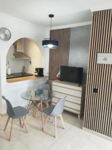 a living room with a table and chairs and a tv at Casa Playa de la Mata in La Mata