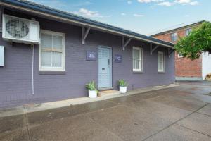 a purple house with two potted plants in front of it at CitySide Pad in Tamworth
