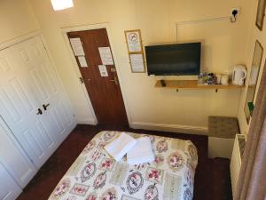 a room with a bed and a tv and a door at The Arabella in Blackpool