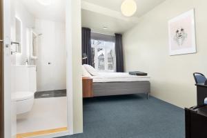 ein kleines Bad mit einem Bett und einem Fenster in der Unterkunft Central Guest House - Bedroom with private Bathroom in Stavanger