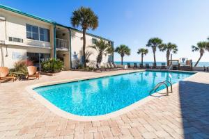 a swimming pool in front of a building and the ocean at Tranquil 3rd Flr Resort View King Room in Pawleys Island
