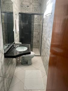 a bathroom with a toilet and a sink and a shower at Hotel Shalom in Juazeiro do Norte