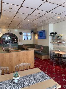 a restaurant with a bar and tables and chairs at The Arabella in Blackpool