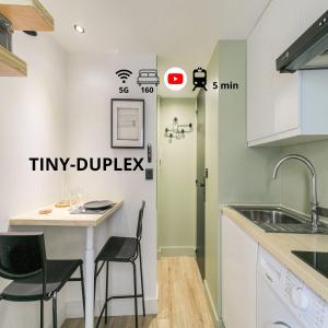 uma cozinha com uma mesa e cadeiras e um lavatório em Tiny-duplex em Lyon