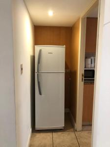 a white refrigerator in a room with a kitchen at Departamento quinta sección in Mendoza