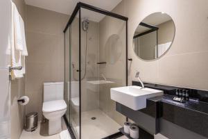 a bathroom with a toilet and a sink and a mirror at House of Charlie Vila Mariana in São Paulo