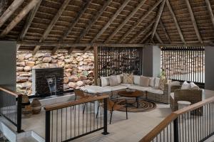 - un salon avec un canapé et une cheminée dans l'établissement Leopard Sands Kruger Park, à Skukuza