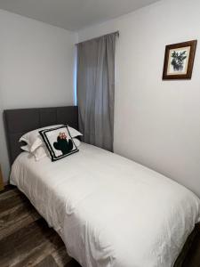 a bedroom with a white bed with a picture on it at Entire House and Home in Whitehorse Downtown in Whitehorse