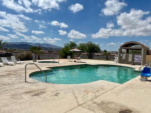 una piscina en un patio con sillas y un cielo en Studio 6 Suites Lake Havasu City AZ, en Lake Havasu City