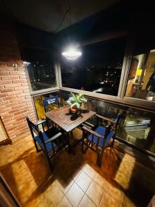 a table and chairs on a balcony at night at Refugio Urbano in Cordoba