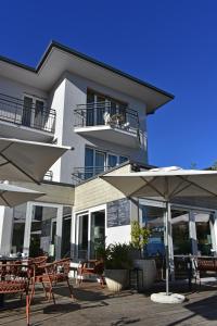 a building with tables and umbrellas in front of it at Hotel Marolda in Sirmione