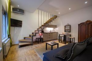 un soggiorno con divano e una scala di Green and Blue Garden Apartments a Belgrado