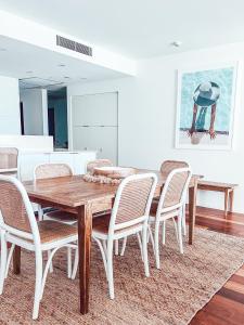 uma sala de jantar com uma mesa de madeira e cadeiras em The Beach Cabarita em Cabarita Beach