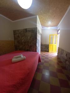 a bedroom with a red bed and a yellow door at Humahuaca Hostel in Humahuaca