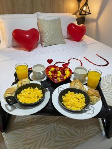 a tray of breakfast food on a bed with hearts at GRAND HOTEL JAMUNDI in Jamundí