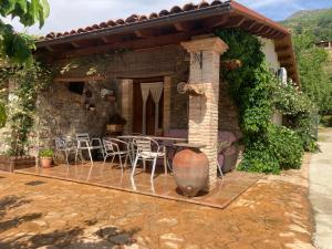 een patio met een tafel en stoelen in een huis bij casa rural La picotina in Navaconcejo