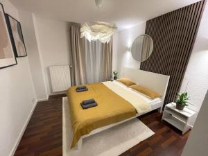 a bedroom with a large bed with a yellow blanket at Charmantes TinyHouse im Zentrum - MalliBase Apartments in Hannover