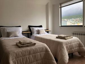 zwei Betten in einem Zimmer mit Handtüchern darauf in der Unterkunft Al fin un mundo in Ushuaia
