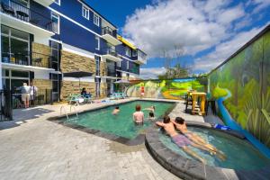 um grupo de pessoas em uma piscina com um parque aquático em Urban Lounge Sleepery em Rotorua