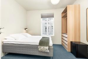 um quarto com uma cama grande e uma janela em Central Guest House - Bedroom with private Bathroom em Stavanger