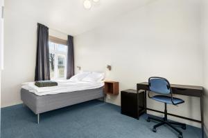 a bedroom with a bed and a desk and a chair at Central Guest House - Bedroom with private Bathroom in Stavanger