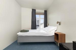 uma cama num quarto com uma janela em Central Guest House - Bedroom with private Bathroom em Stavanger