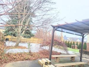 un banco de madera bajo un pabellón en un parque en Cozy Home Close to Attractions in Niagara Falls en Thorold