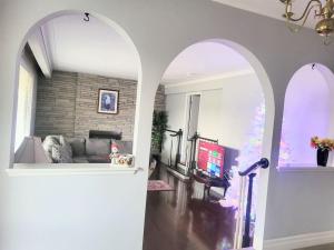 sala de estar con arco y sala de estar con sofá en Cozy Home Close to Attractions in Niagara Falls en Thorold