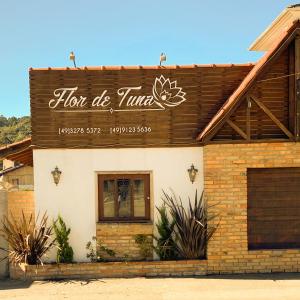 a building with a sign on the side of it at Pousada Flor de Tuna in Urubici