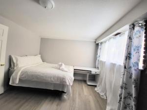 ein kleines Schlafzimmer mit einem Bett und einem Fenster in der Unterkunft Cozy Home Close to Attractions in Niagara Falls in Thorold