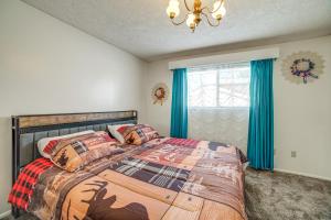 a bedroom with a bed and a window with blue curtains at Idaho Vacation Rental Day Trip to Yellowstone! in Sugar City