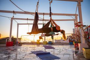 a woman swinging in a hammock on a patio at Adventurekeys Surf Yoga Cowork in Taghazout