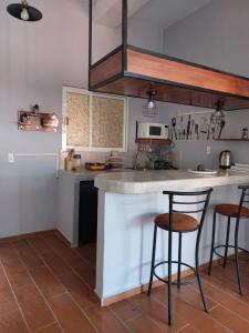 a kitchen with two bar stools and a counter at Harmony Loft in San Martín de las Pirámides