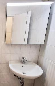 een witte wastafel in een badkamer met een spiegel bij 3 Zimmer Apartment in Wuppertal