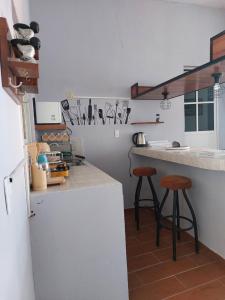 a kitchen with a counter and two stools in it at Harmony Loft in San Martín de las Pirámides