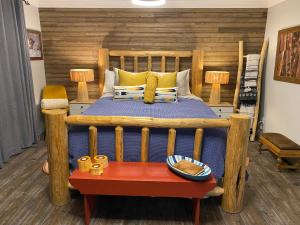 a bedroom with a wooden bed with a wooden headboard at Rayleigh Riverfront Retreat- Peaceful Garden Oasis-25 MINUTES TO SKI HILL in Kamloops