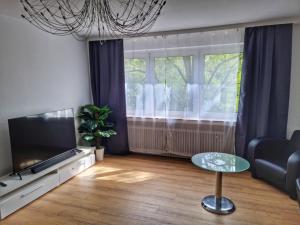 een woonkamer met een tv en een tafel bij 3 Zimmer Apartment in Wuppertal
