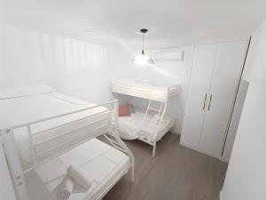 Habitación blanca con 2 literas y armario en City Castle, Granada center, casa completa, en Granada