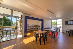 a room with tables and chairs and a balcony at Urban Lounge Sleepery, SureStay Collection by BW in Rotorua
