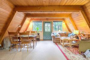 un soggiorno con divano e tavolo di Douglas Island A-frame Cabin in the Woods a Juneau