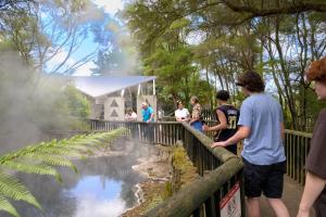 Eine Gruppe von Menschen, die auf einem Zaun stehen und einen Teich ansehen in der Unterkunft Urban Lounge Sleepery in Rotorua