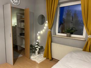 Schlafzimmer mit einem Bett und einem Fenster mit gelben Vorhängen in der Unterkunft Gemütliche Garconniere im Zentrum von Pregarten in Pregarten