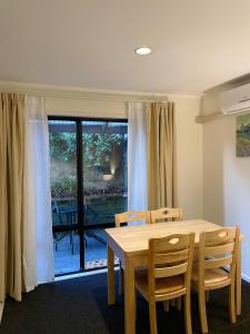 a dining room with a table and chairs and a window at Royal Park Lodge in Auckland