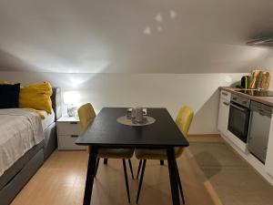 eine kleine Küche mit einem Tisch und Stühlen in einem Zimmer in der Unterkunft Gemütliche Garconniere im Zentrum von Pregarten in Pregarten