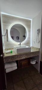 W łazience znajduje się umywalka i lustro. w obiekcie Hacienda Suites Loreto w mieście Loreto