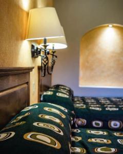 a hotel room with a bed and a lamp at Hacienda Suites Loreto in Loreto