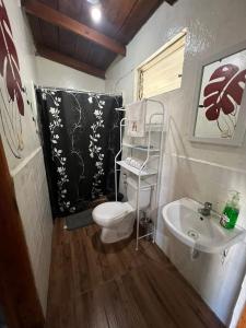 a small bathroom with a toilet and a sink at Cabaña de Atitlan in Panajachel