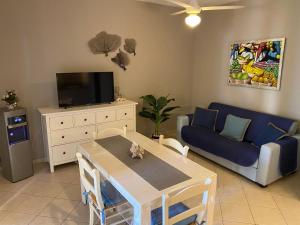 a living room with a table and a blue couch at Esmeralda67 Tamarindo in Bayahibe