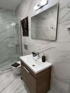 a bathroom with a sink and a toilet and a mirror at Academy's Modern Apartments By Aesthetic & Luxurious Living in Athens