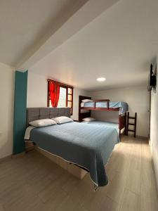 a bedroom with a bed and two bunk beds at Hospedaje Vacacional y Familiar Baños in Baños